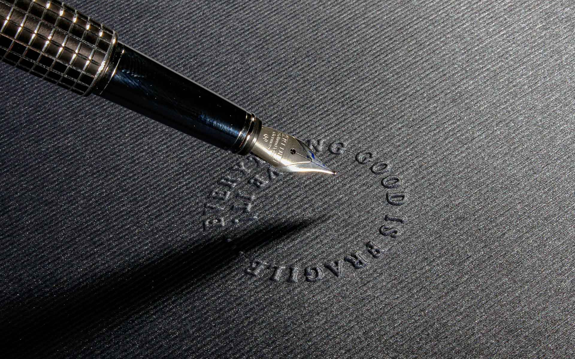 Blindprägung eines Credos auf texturierten Naturpapier.
